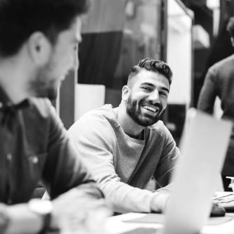 Two colleagues smiling at their desks