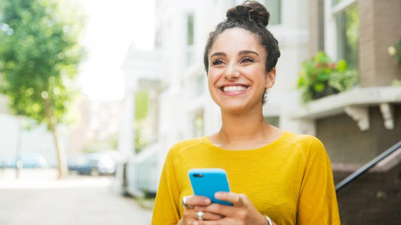 Mulher sorrindo segurando o celular